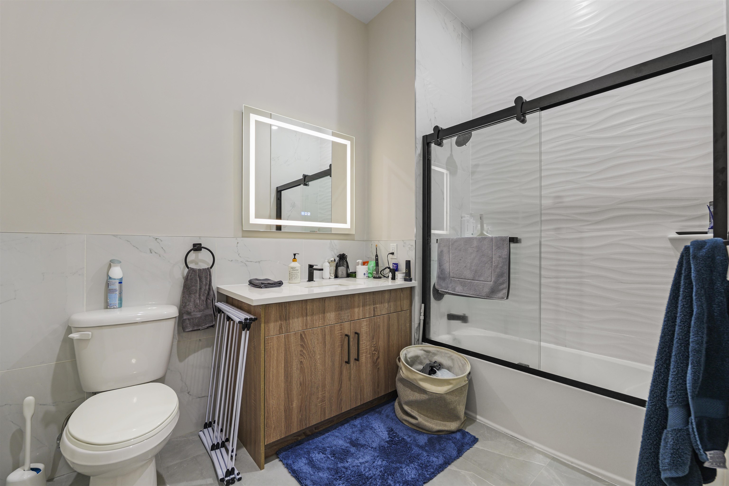 212 70th Street, Unit 404 Guttenberg, NJ 07093 - Photo 9 of 14 a bathroom with a toilet a sink and mirror