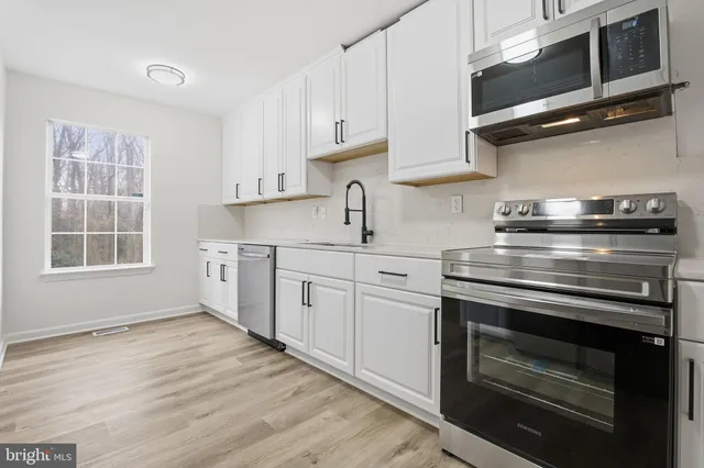 a kitchen with stainless steel appliances granite countertop a stove and a microwave