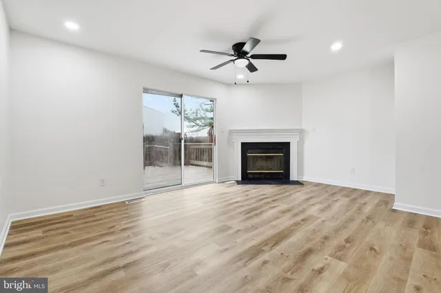 an empty room with fireplace and fan