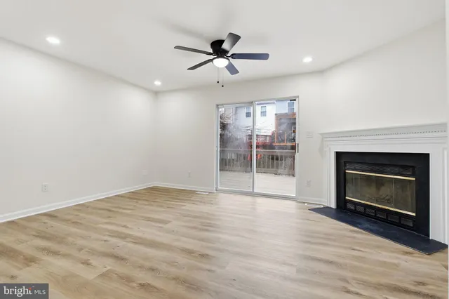 a view of empty room with wooden floor and fireplace
