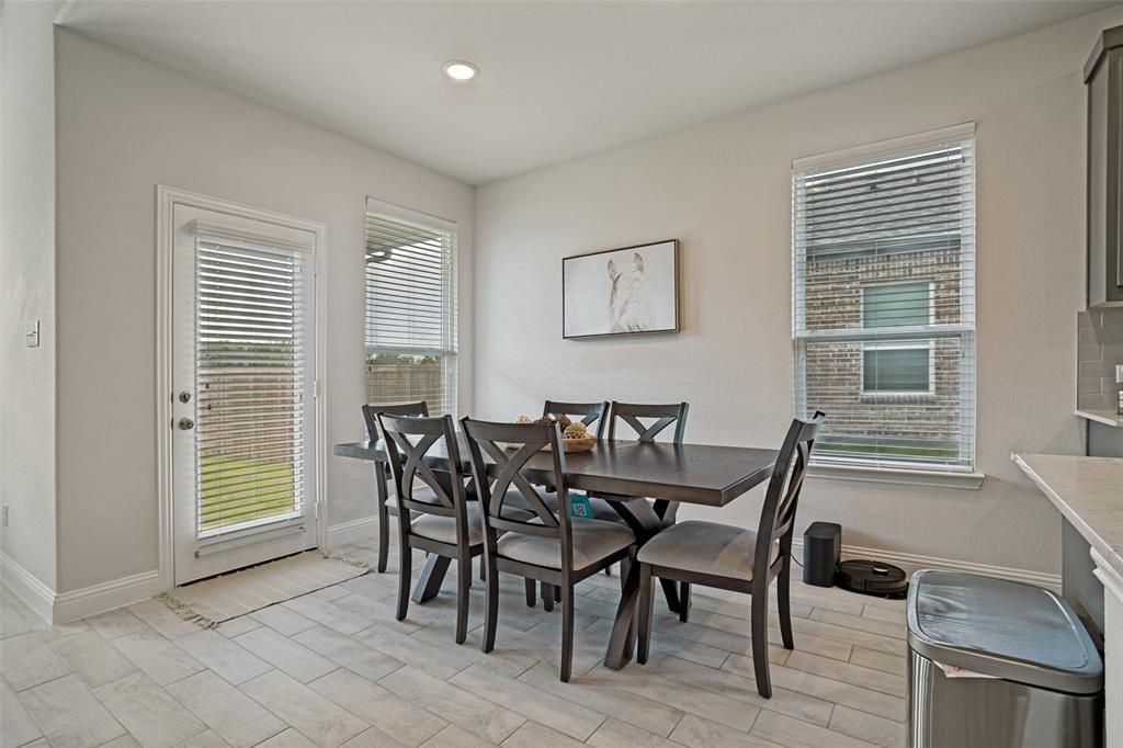 3115 Giovanni Point Princeton, TX 75407 - Photo 12 of 26 Dining area featuring light wood-finish flooring, a patio door with integrated blinds, and two windows with blinds