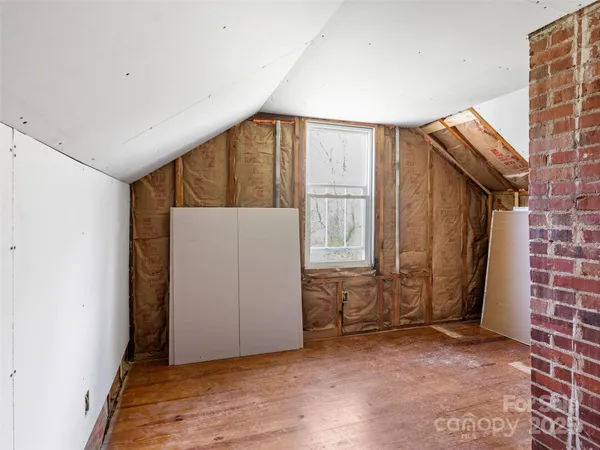 a view of an empty room with brick walls