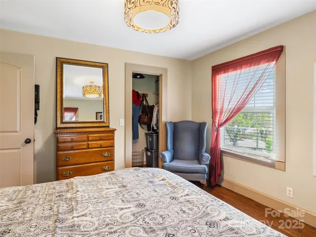 a bedroom with a bed and a dresser next to a window