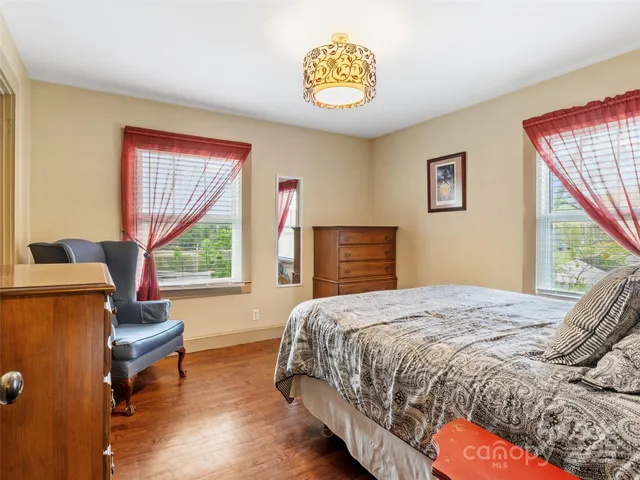 a bedroom with a bed and a dresser next to a window