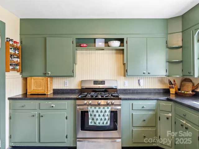 a kitchen with granite countertop a sink a stove and cabinets