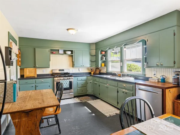 a kitchen with a table chairs sink and cabinets