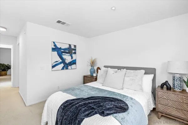 a bedroom with a bed and a painting on the wall