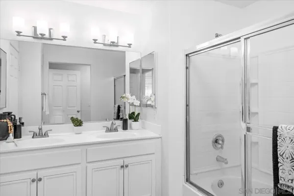 a bathroom with a double vanity sink mirror and shower