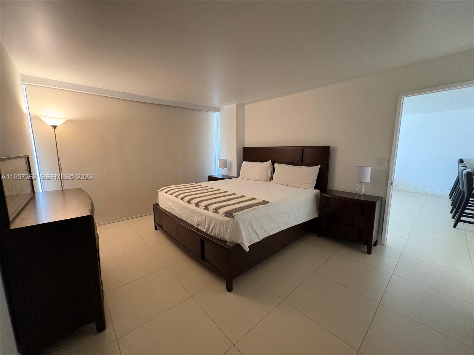 1865 Brickell Avenue, Unit A810 Miami, FL 33129 - Photo 13 of 24 a bedroom with a bed lamp and a potted plant