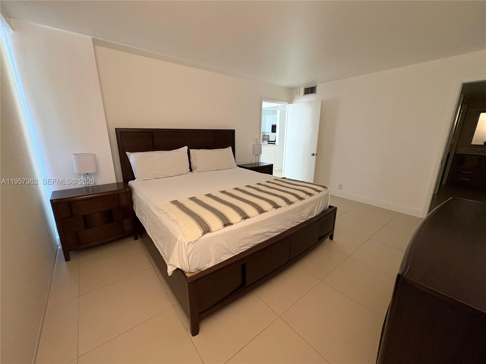 1865 Brickell Avenue, Unit A810 Miami, FL 33129 - Photo 14 of 24 a large bed sitting in a bedroom next to a small yard