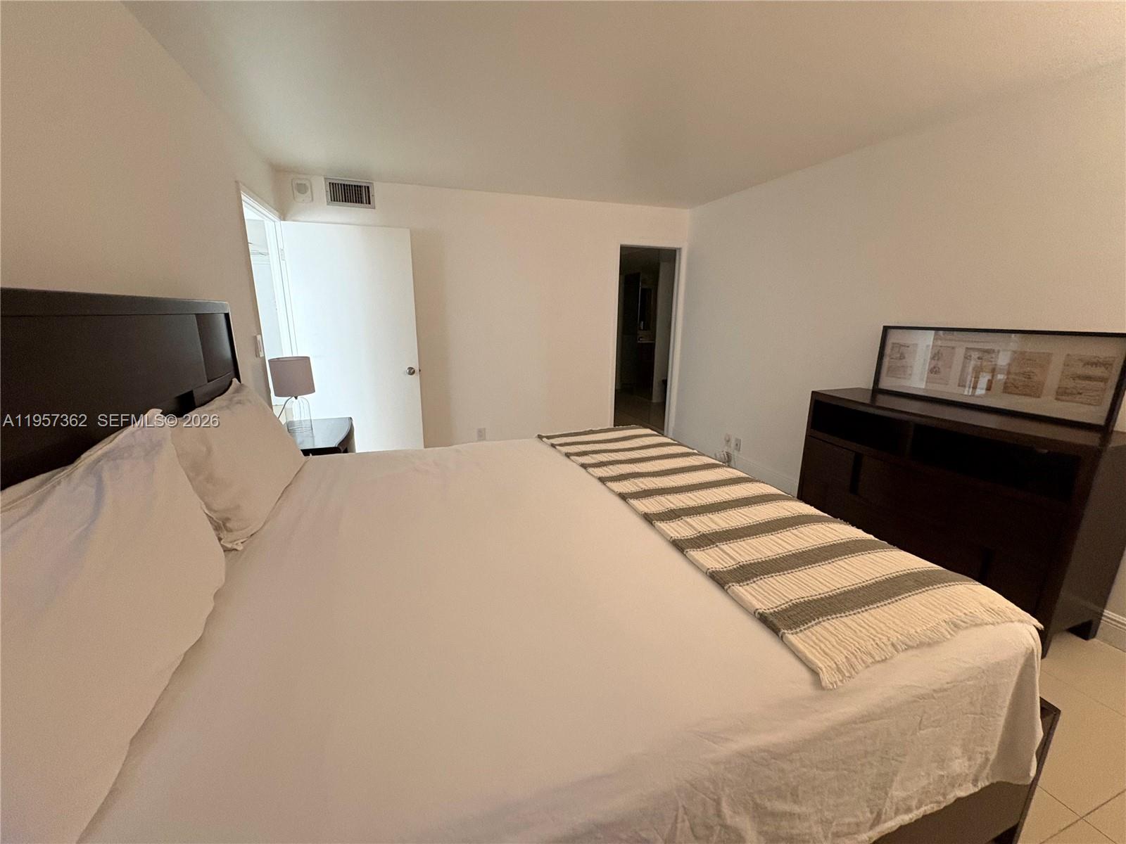 1865 Brickell Avenue, Unit A810 Miami, FL 33129 - Photo 16 of 24 a bedroom with a bed and wooden floor