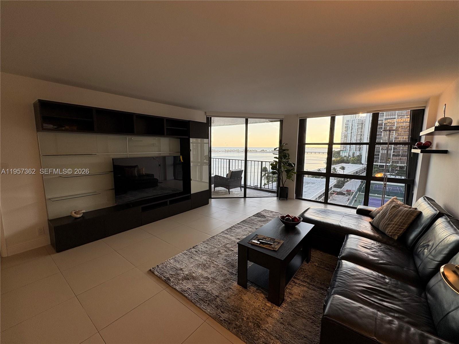 1865 Brickell Avenue, Unit A810 Miami, FL 33129 - Photo 3 of 24 a living room with furniture fireplace and a flat screen tv