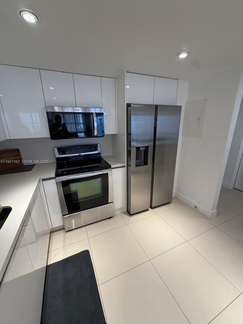 1865 Brickell Avenue, Unit A810 Miami, FL 33129 - Photo 6 of 24 a kitchen with stainless steel appliances kitchen island granite countertop a stove and a refrigerator