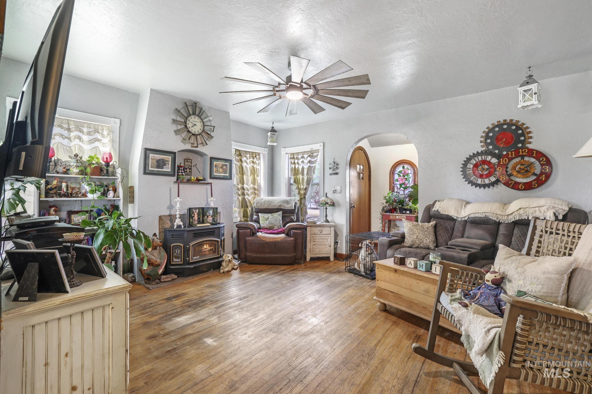 602 4th Avenue East Gooding, ID 83330 - Photo 3 of 36 Living area with a wood stove, arched walkways, hardwood / wood-style flooring, a textured ceiling, and a textured wall