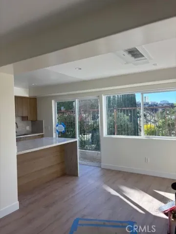 a living room with wooden floor and a large window