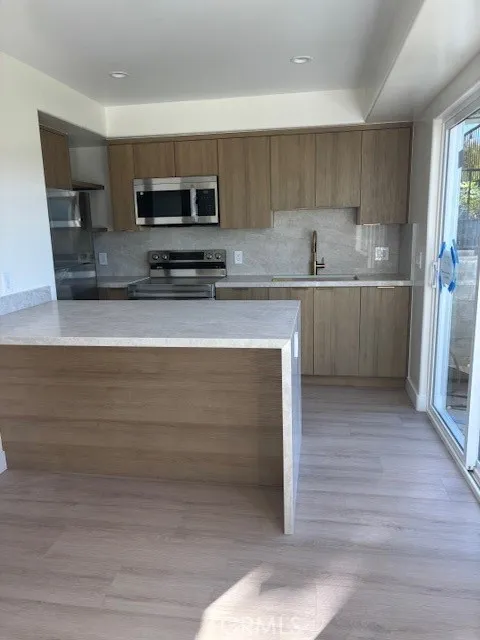 26173 Abdale Street Newhall, CA 91321 - Photo 4 of 15 a kitchen with stainless steel appliances granite countertop a stove a sink and a microwave