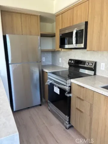 a kitchen with stainless steel appliances a stove microwave and refrigerator