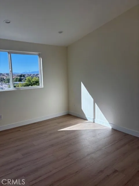 26173 Abdale Street Newhall, CA 91321 - Photo 7 of 15 a view of an empty room with a window and wooden floor