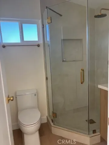 a bathroom with a toilet and a shower