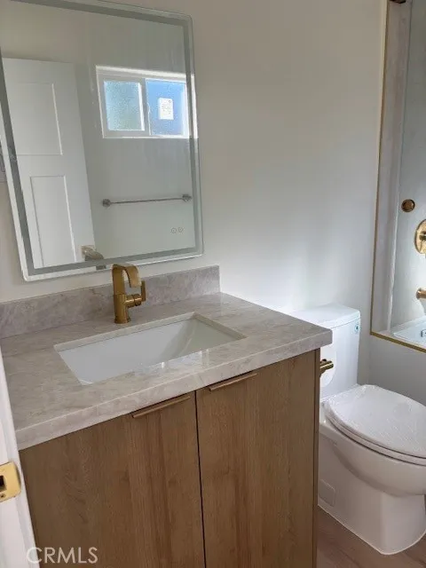 26173 Abdale Street Newhall, CA 91321 - Photo 10 of 15 a bathroom with a granite countertop sink a toilet and a mirror