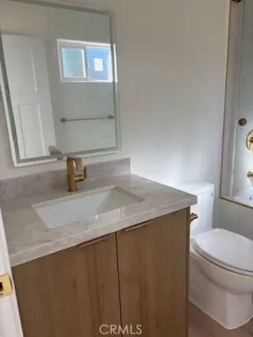 a bathroom with a sink a toilet and mirror