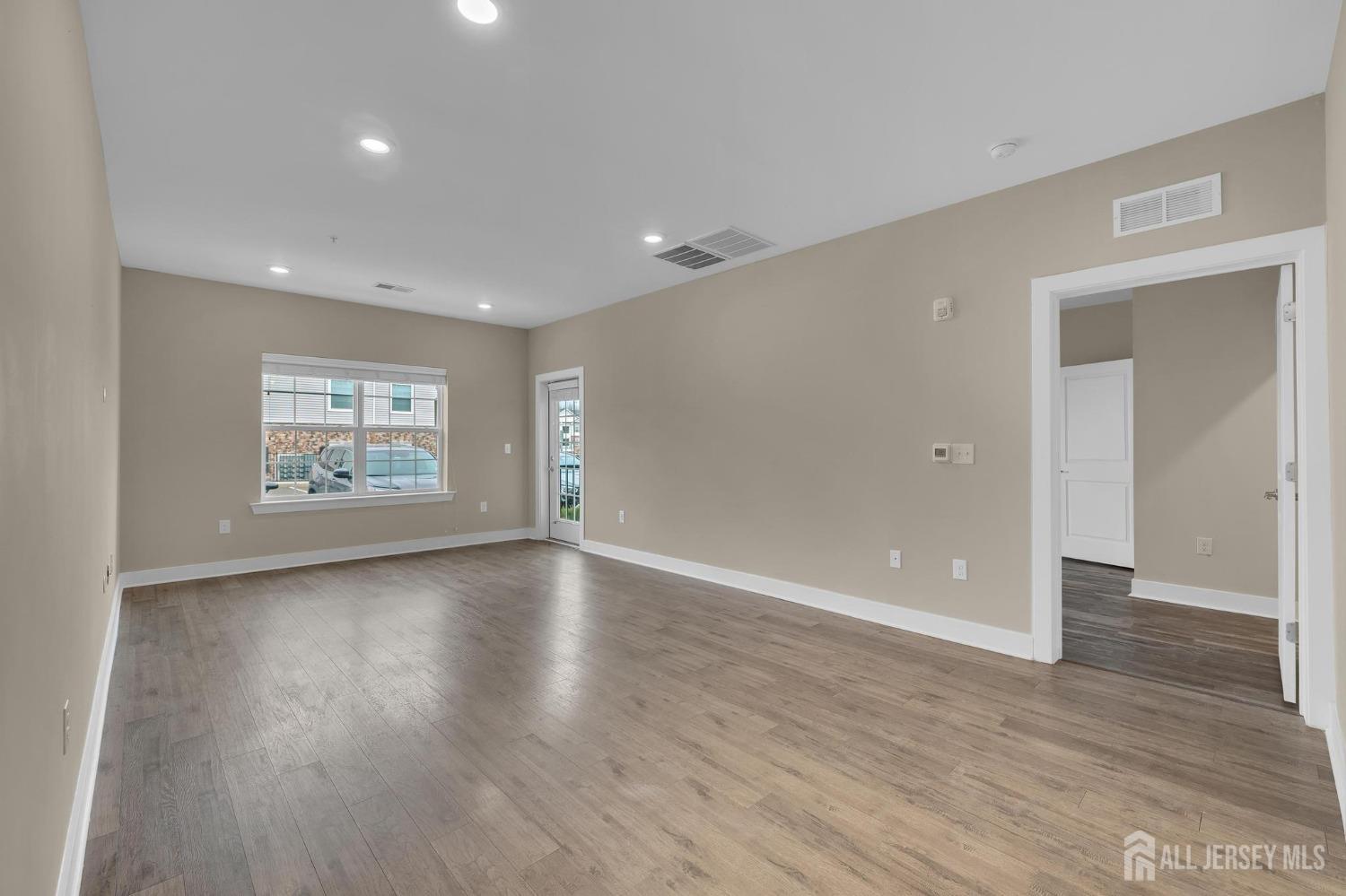415 Tavern Road Monroe Township, NJ 08831 - Photo 13 of 39 a view of an empty room with wooden floor and a window
