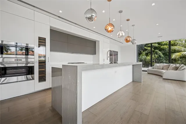 a kitchen with stainless steel appliances kitchen island granite countertop a stove and a sink with living room