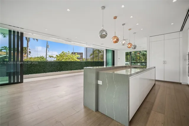a large white kitchen with a large window and stainless steel appliances