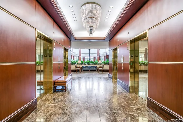 a view of a hallway with wooden floor and a potted plant