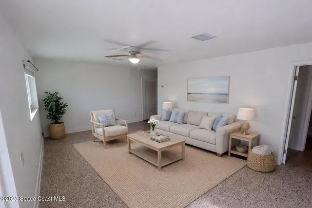 a living room with furniture and a potted plant