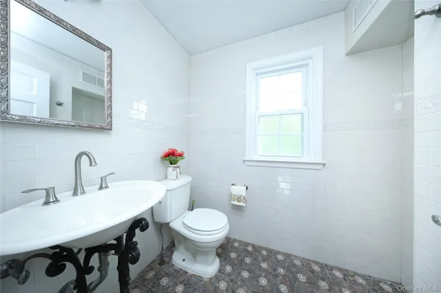 a bathroom with a toilet a sink and a mirror