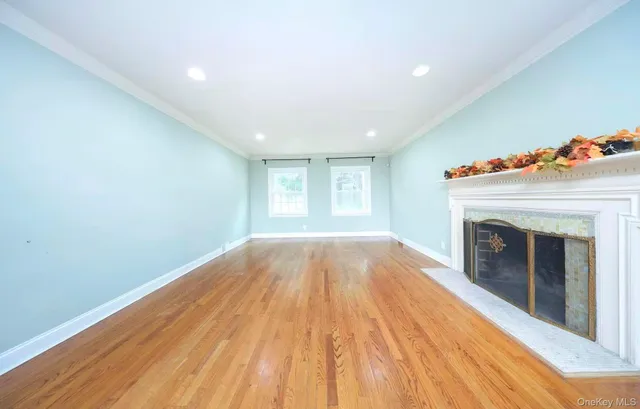 a view of empty room with wooden floor and fireplace