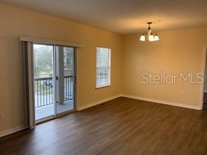 1555 Scarlet Oak Loop, Unit 113A Winter Garden, FL 34787 - Photo 2 of 11 a view of an empty room with wooden floor and a window