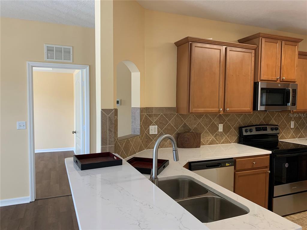 1555 Scarlet Oak Loop, Unit 113A Winter Garden, FL 34787 - Photo 4 of 11 a kitchen that has a microwave a sink and a stove in it