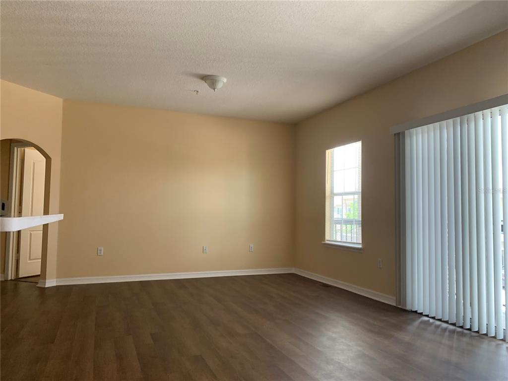1555 Scarlet Oak Loop, Unit 113A Winter Garden, FL 34787 - Photo 6 of 11 an empty room with wooden floor and windows