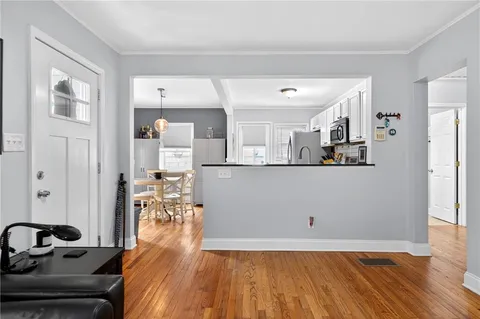 a view of a living room and kitchen with wooden floor