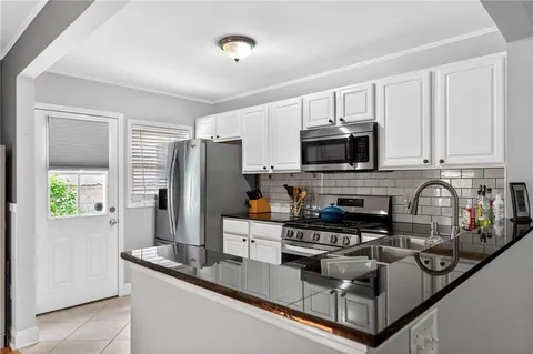 a kitchen with stainless steel appliances granite countertop a stove a sink and a microwave
