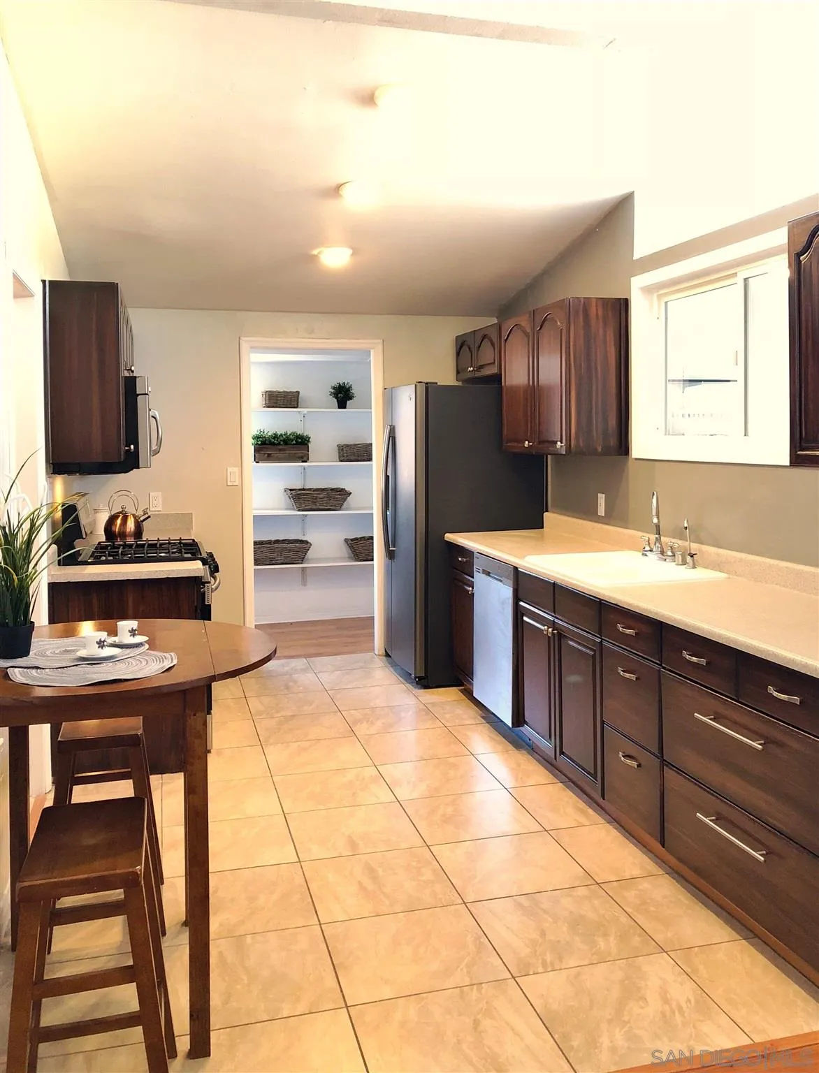 13727 Powers Road Poway, CA 92064 - Photo 3 of 4 a kitchen with stainless steel appliances granite countertop a stove a sink and a refrigerator