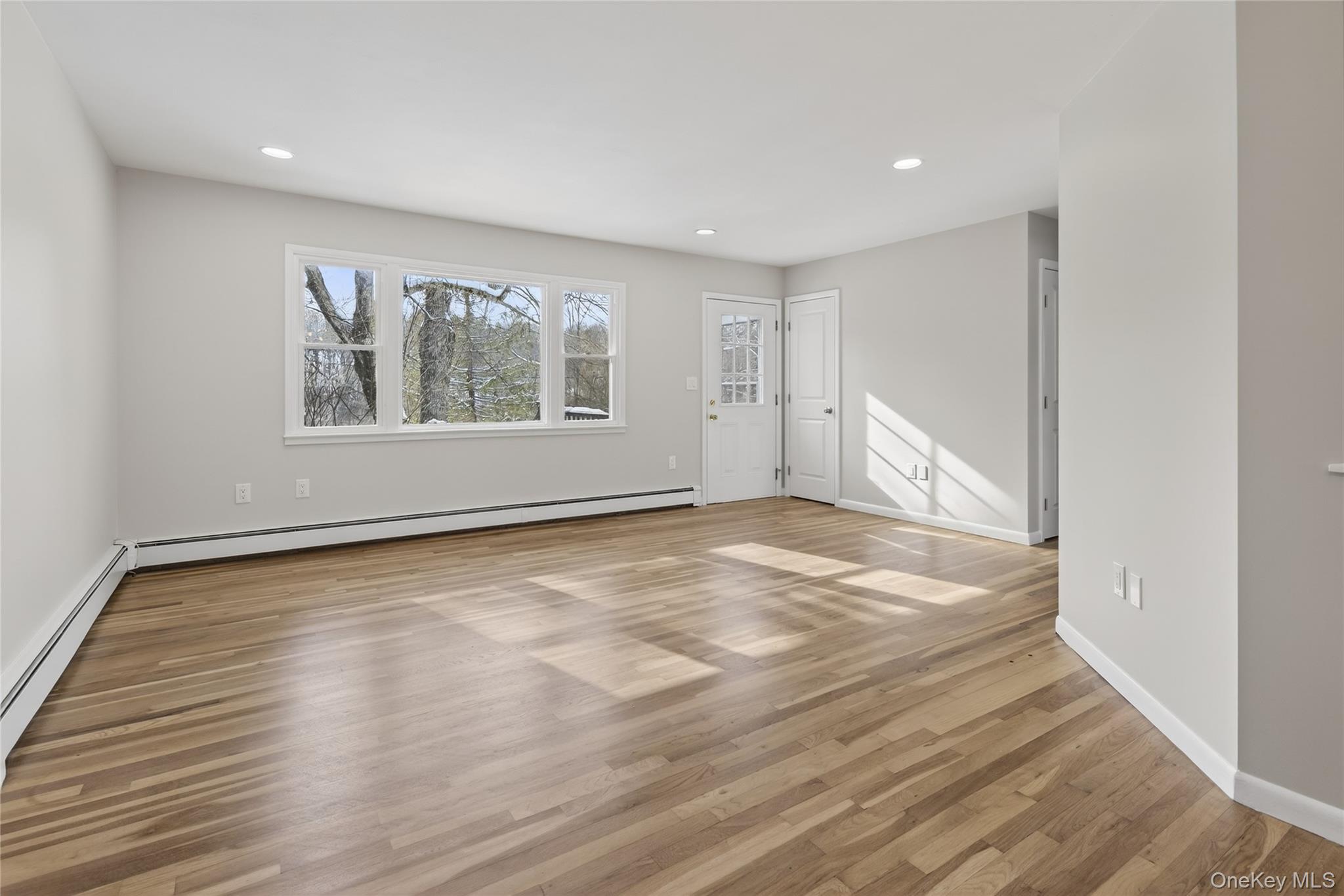 676-678 Oak Summit Road Millbrook, NY 12545 - Photo 9 of 22 a view of an empty room with wooden floor and a window