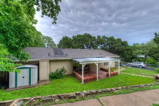 a view of house with garden and outdoor seating