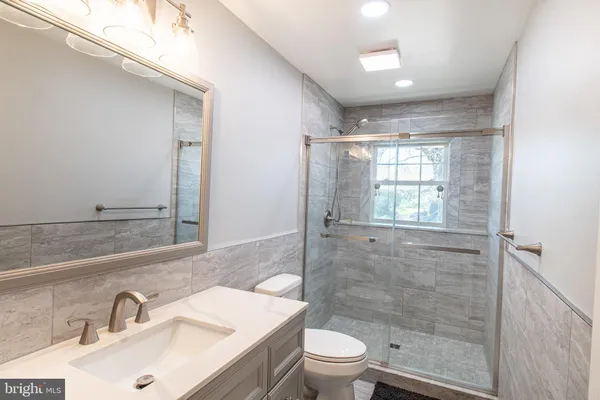 a bathroom with a sink toilet and shower