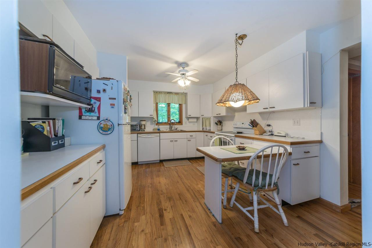 366 Buck Road Stone Ridge, NY 12484 - Photo 12 of 26 a kitchen with stainless steel appliances granite countertop a sink stove and wooden floor
