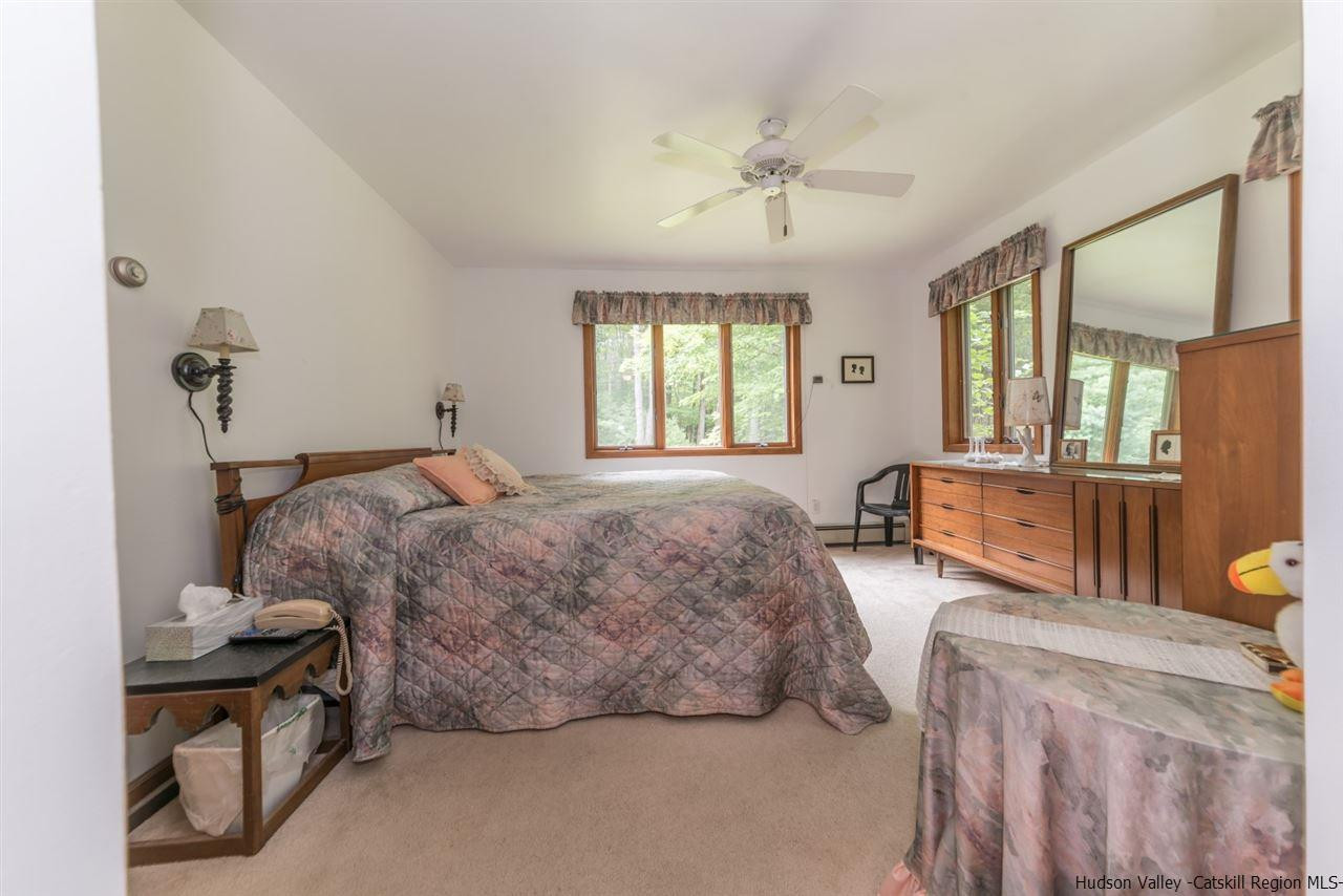 366 Buck Road Stone Ridge, NY 12484 - Photo 14 of 26 a spacious bedroom with two beds and chandelier