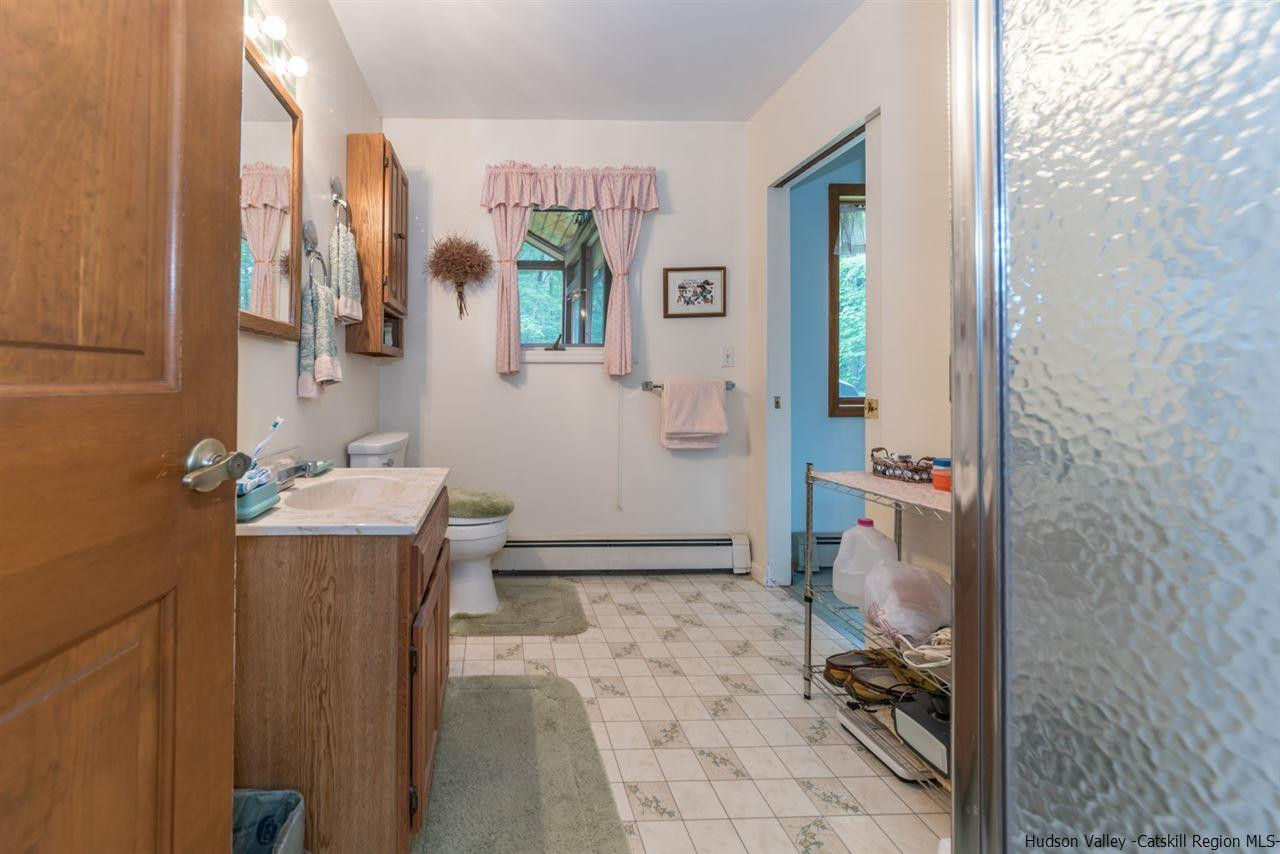 366 Buck Road Stone Ridge, NY 12484 - Photo 19 of 26 a bathroom with a sink mirror vanity and toilet