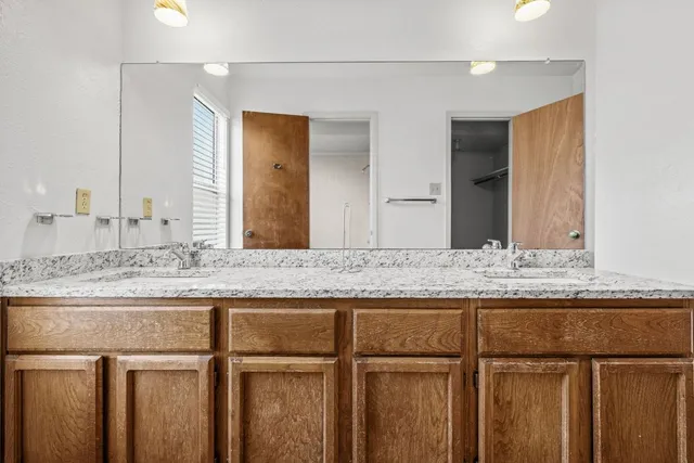 a bathroom with a granite countertop sink and a mirror
