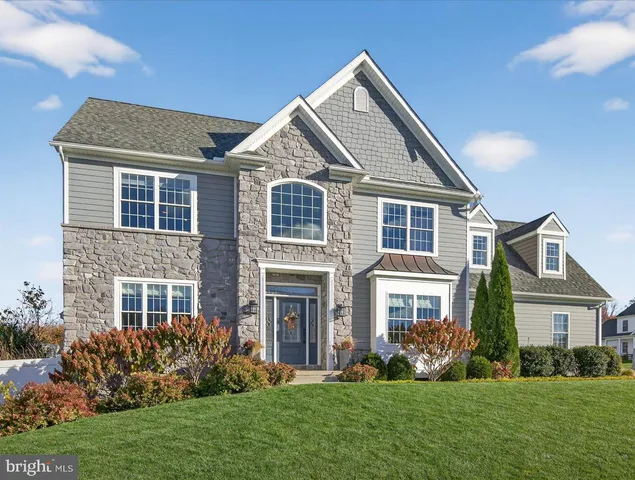 a front view of a house with a yard and trees