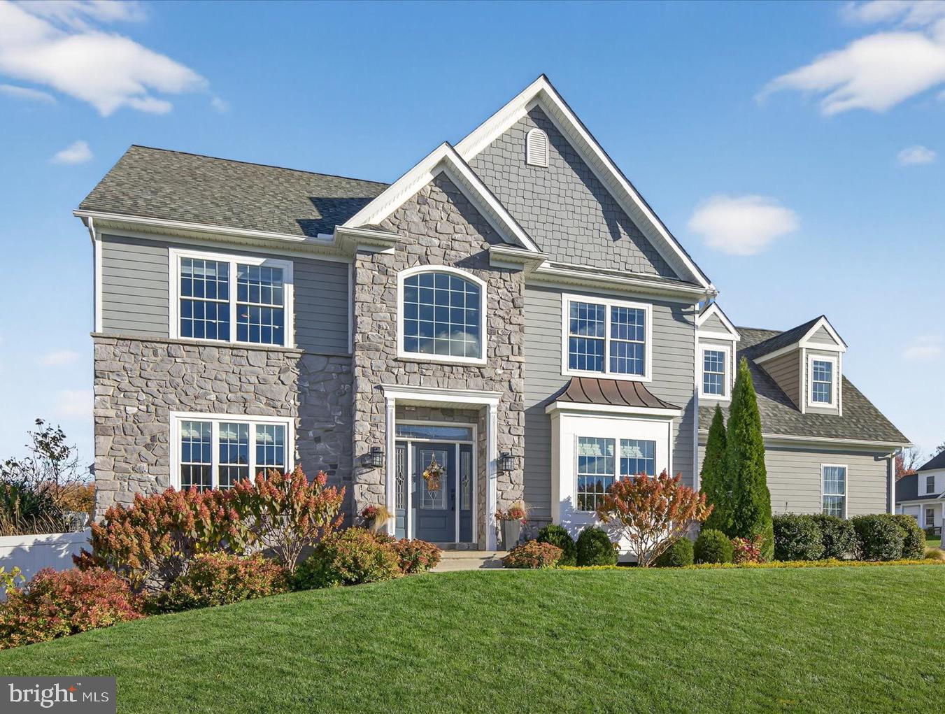 a front view of a house with a yard and trees