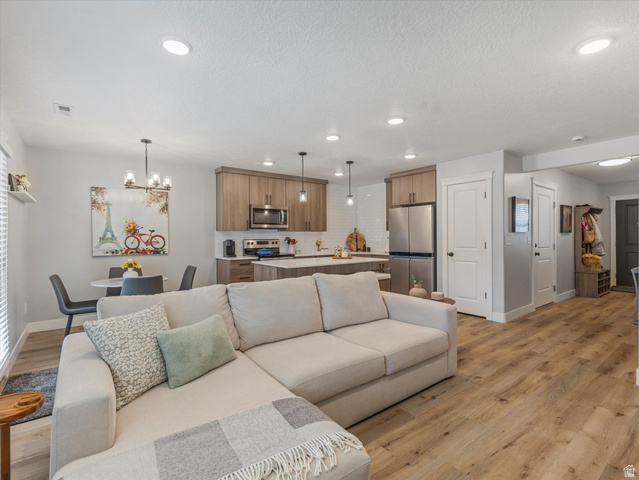 3047 Old Emigrant Road, Unit C Syracuse, UT 84075 - Photo 5 of 20 Living area featuring light wood-style flooring and hanging lights