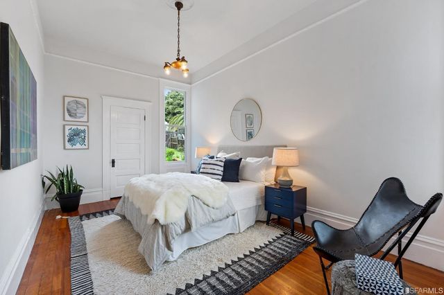 a bedroom with bed and a chandelier
