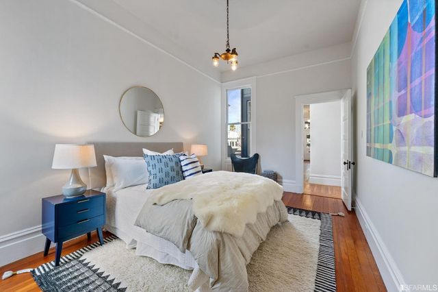 a bedroom with bed and wooden floor